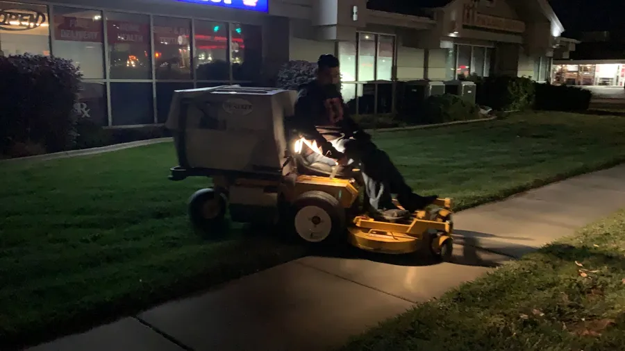 Mowing a commercial lawn after dark