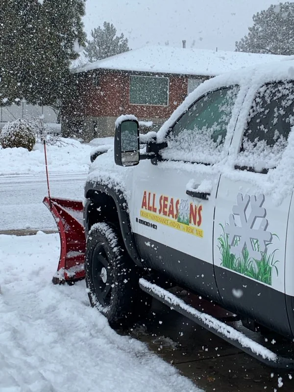 The All Seasons truck with its red plow after a snowfall in Roy, UT